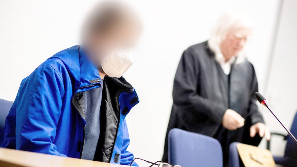 Der Angeklagte sitzt vor Prozessbeginn in einem Gerichtssaal im Landgericht neben seinem Anwalt Reinhard Nollmann (rechts). Der angeklagte Mann soll im Juni 2022 in Cloppenburg seine zwei Monate alte Tochter durch Schläge getötet haben. Foto: Dittrich/dpa