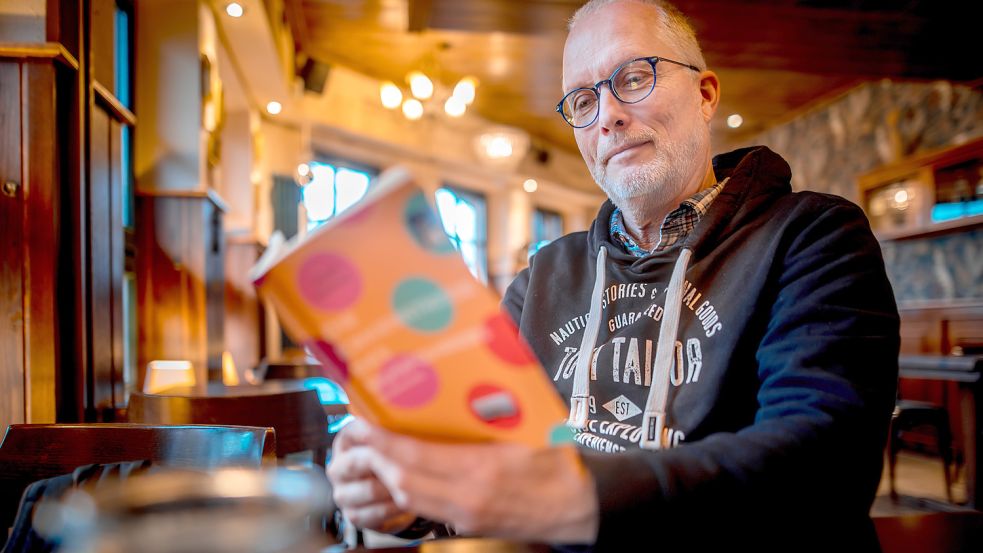 Martin Kaminski blättert in den frisch erschienenen „Erkenntnissen des Busfahrers“. Foto: Cordsen