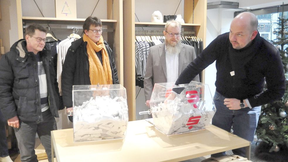 Christian Hildebrandt (Kinderschutzbund), Jutta Blank (Lebenshilfe) und Notar Ulf Nannen schauten zu wie Henning Kruse (Werbegemeinschaft) die Gewinner zog. Foto: Wolters