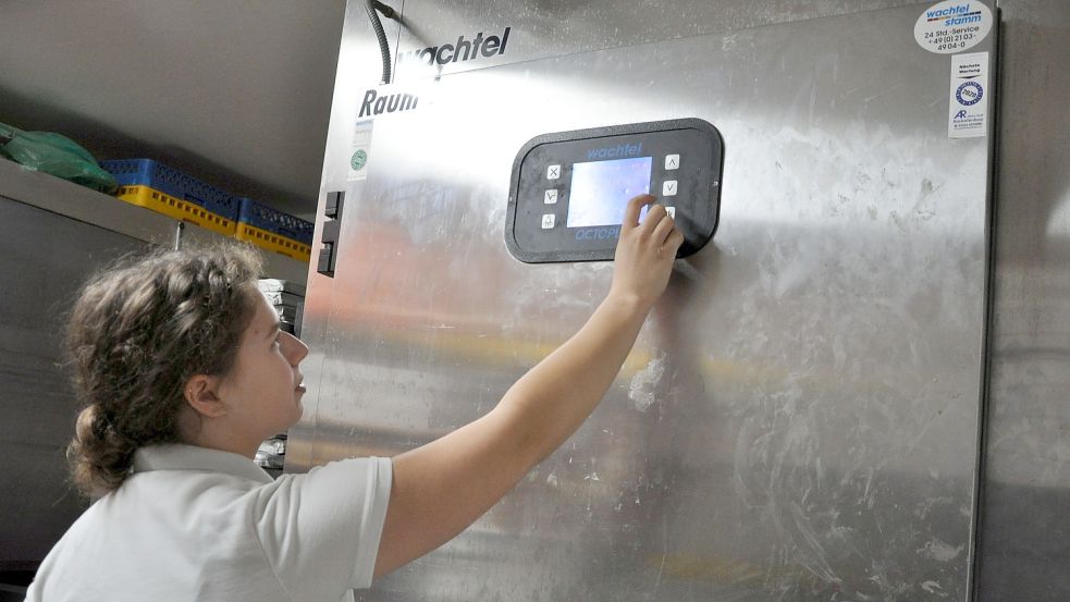 Bianca Edzards stellt die niedrigen Temperaturen ein, bei der Brötchen vor dem Backen gelagert werden. Dank dieser Technik beginnt der Arbeitstag bei Hinrichs deutlich später als in vielen anderen Bäckereien. Foto: Ullrich