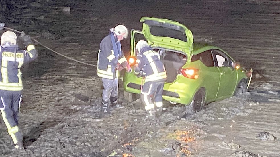 Feuerwehrleute bargen das Fahrzeug aus dem Watt. Fotos: Siebels/Feuerwehr Dornum