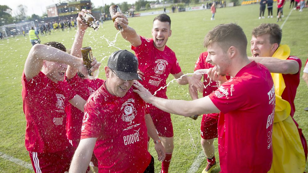 Im Mai gab es für Trainer Matthias Schmidt (vorne) nach dem Bezirksliga-Titel natürlich auch eine Sektdusche der Spieler. Foto: Doden/Emden