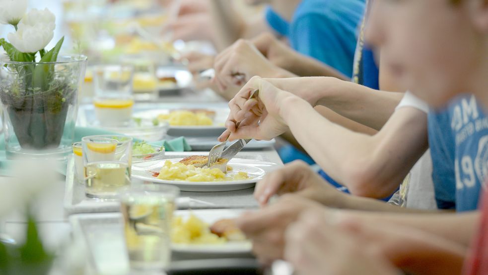 Schülerinnen und Schüler essen in einer Mensa. In Emden wird ein neuer Caterer für die Mittagsverpflegung gesucht. Das hatte sich schon in Vorjahren als kompliziert erwiesen. Symbolfoto: Franziska Kraufmann/Dpa