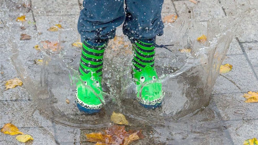 Regen ist für Kinder mit Gummistiefeln ein Heidenspaß. Wenn eine Stadt allerdings die Infrastruktur für die Ableitung des Regenwassers tragen muss, belastet das den Haushalt. Deshalb fordern einige Politiker seit Jahren in Aurich eine Regenwassergebühr. Doch die lässt auf sich warten. Foto: Archiv