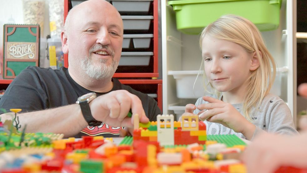 Wer schon im Kindesalter beispielsweise das Bauen nach Anleitung lernt, hat es später leichter. Frank Boor zeigt Tessa, wie man auch ohne konkreten Plan ein Haus entstehen lassen kann. Foto: Ortgies
