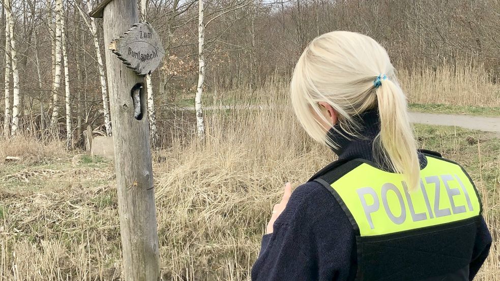 Eine Polizistin nimmt die Schäden an einem der Wegweiser auf. Foto: H. Müller