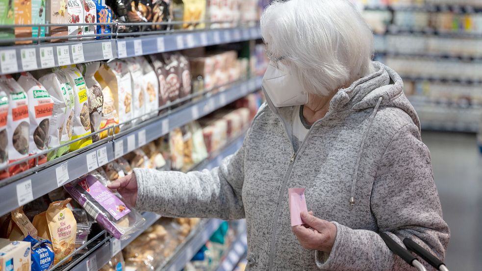 Diese ältere Frau schützt sich freiwillig mit einer Maske vor Krankheiten, aber auch die Geldbörse muss geschützt werden. Foto: Marijan Murat/dpa