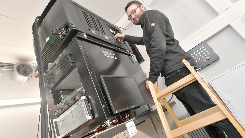 Veranstaltungstechniker Lasse Kracht muss auf die Leiter, um an den Projektor zu kommen. Foto: Ortgies