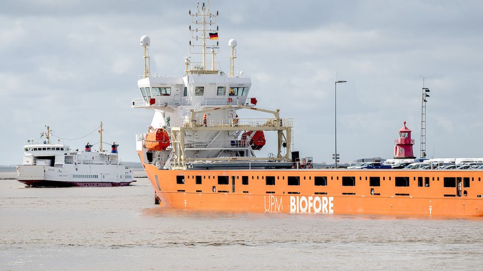 Ein Frachtschiff liegt im Außenhafen, während die Inselfähre „Westfalen“ der Reederei AG Ems in den Emder Hafen einfährt. Die niedersächsischen Häfen haben Zuwächse bei Frachtumschlag und Passagieren erzielt. Foto: Dittrich/dpa