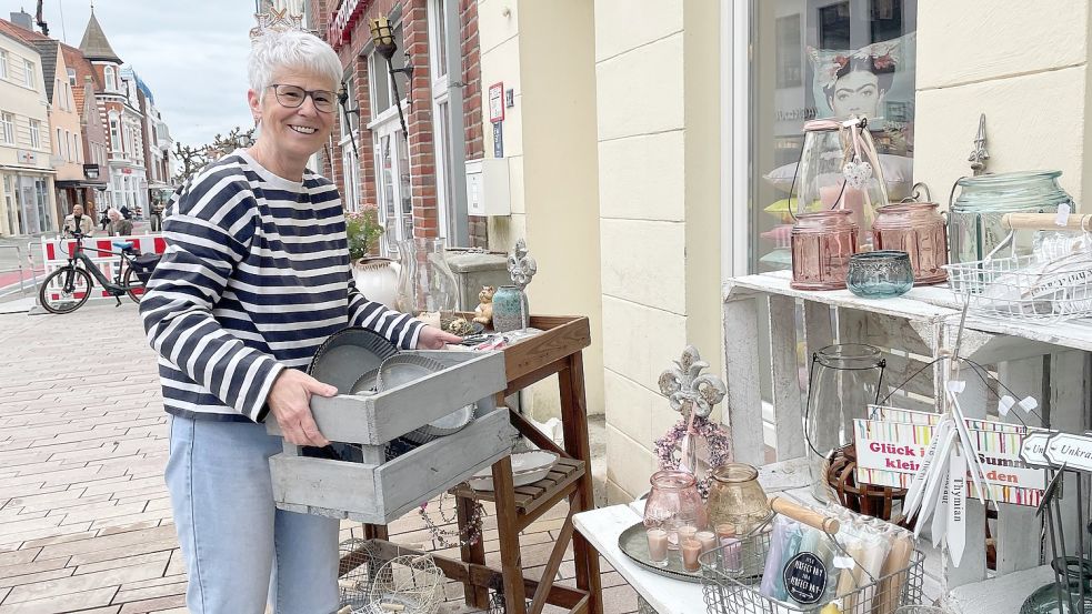 Bettina Rademaker ist froh, dass sie ihre Waren wieder nach draußen stellen kann. Das Pflaster vor ihrem Geschäft in der Burgstraße ist nämlich seit Dienstag verlegt. Foto: Ortgies