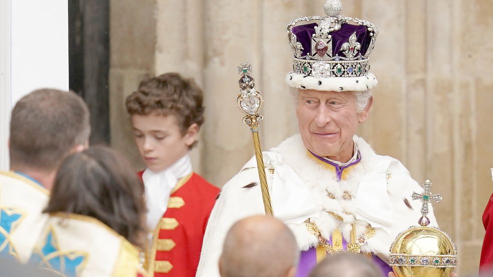 Skurril oder würdevoll? Großbritanniens König Charles III. verlässt nach der Krönungszeremonie mit der Imperial State Crown, einem Zepter und dem Reichsapfel die Westminster Abbey. Foto: PA Wire