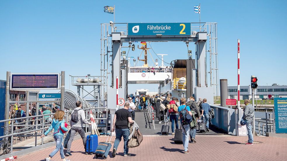 Reisende gegen in Norddeich zur Fähre. Der Sommer 2022 war für die Tourismusbranche in Ostfriesland eine gute Saison. Foto: Schuldt/DPA