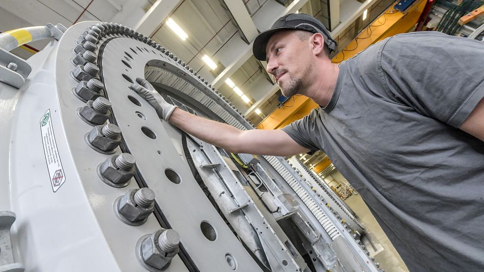 Mitarbeiter Daniel Kaps an einem Blattflanschlager einer Rotornabe. 360 Schraubvorgänge sind pro Seite nötig. Demnächst sollen Roboter hier helfen, die unergonomischen Arbeiten zu übernehmen. Foto: Ortgies