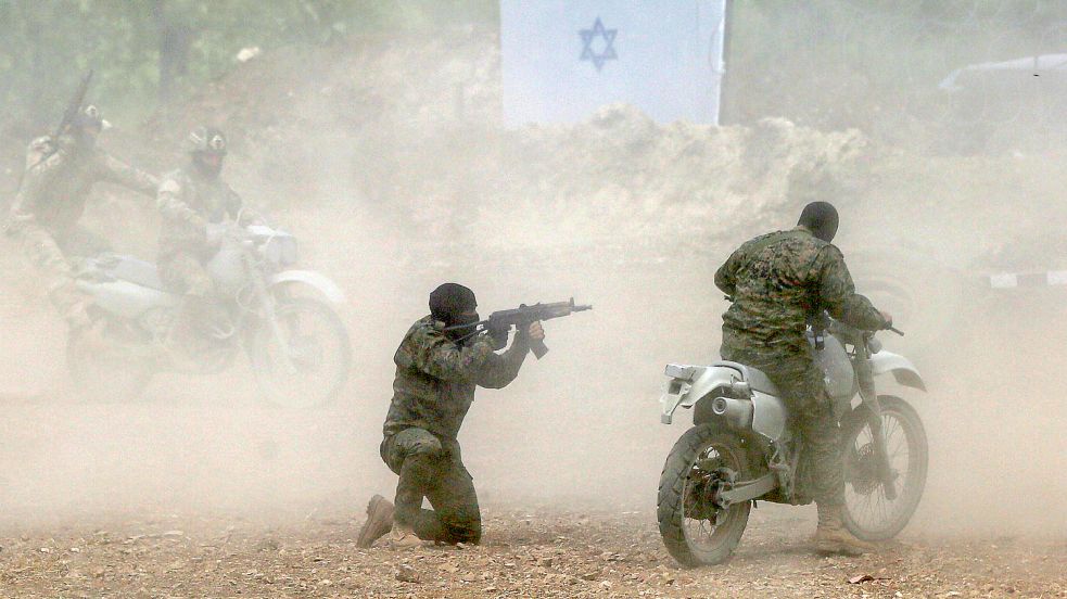 Pro-iranische Hisbollah-Kämpfer simulieren die Entführung eines israelischen Soldaten während einer inszenierten Militärübung in einem Lager im südlibanesischen Dorf Aramta. Foto: Marwan Naamani/dpa