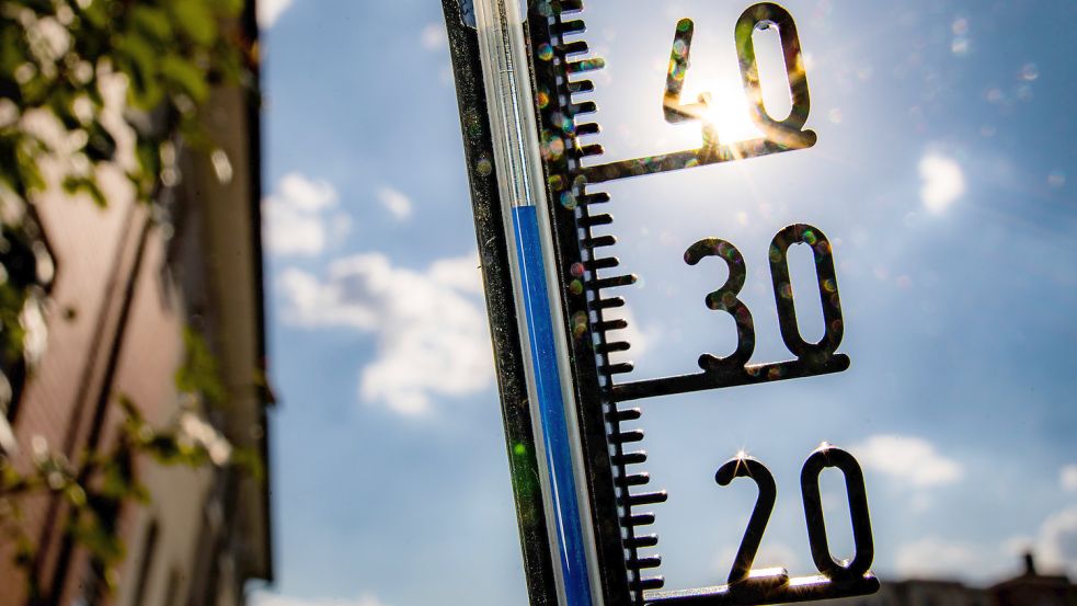 Ein Thermometer an einer Hauswand klettert in Richtung der 40-Grad-Marke.Die Belastung für viele Emder Schüler durch hohe Temperaturen in den Klassenräumen ist hoch. Foto: Rumpenhorst/dpa