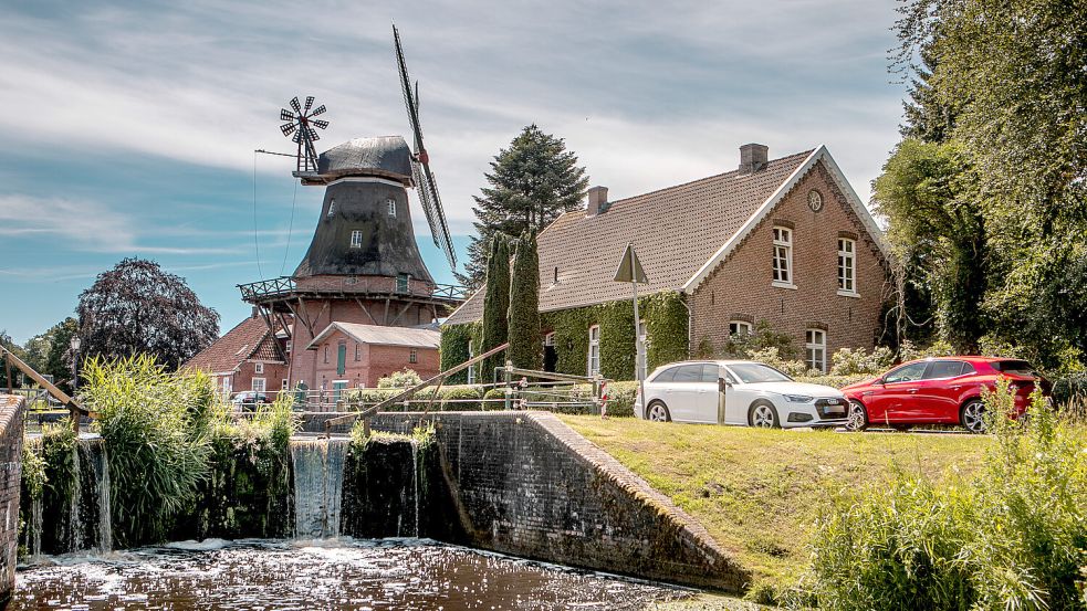 Pittoresk plätschert Wasser über die Schleuse an der Mühle in Westgroßefehn, während sich daneben der Verkehr über die L 14 zwängt. Fotos: Cordsen