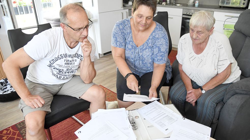 Erika Rux (rechts) musste monatelang auf ihren Internetanschluss warten, den sie benötigt, damit ihr Notfall-Armband funktioniert. Zusammen mit ihren Kindern betrachtet sie den Schriftverkehr mit der EWE, die ihrerseits auf die Telekom angewiesen war. Von links: Ihr Sohn Michael Rux und ihre Tochter Marion Vogelsang. Foto: Ellinger