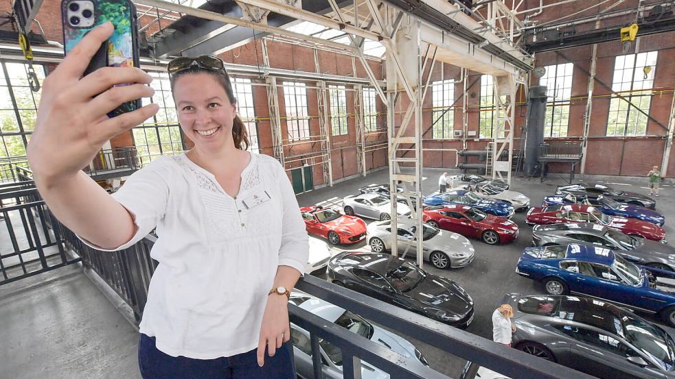 Bianca Griepe macht ein Selfie mit Aston Martin im Hintergrund. Foto: Ortgies