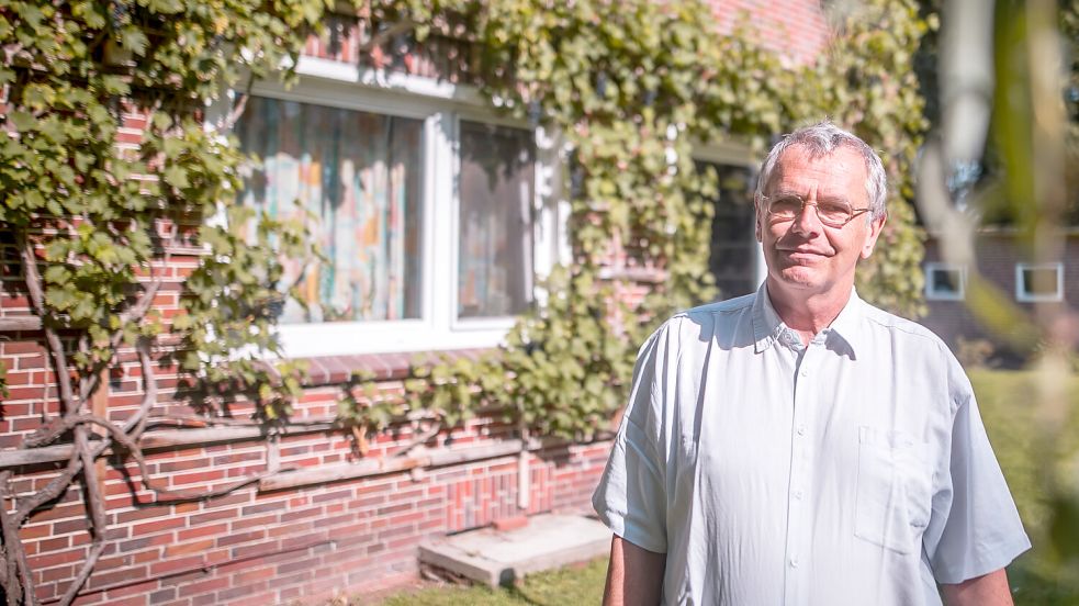Der scheidende Pastor Bernd Battefeld liebt den Weinstock, der am Pfarrhaus in Strackholt rankt.
