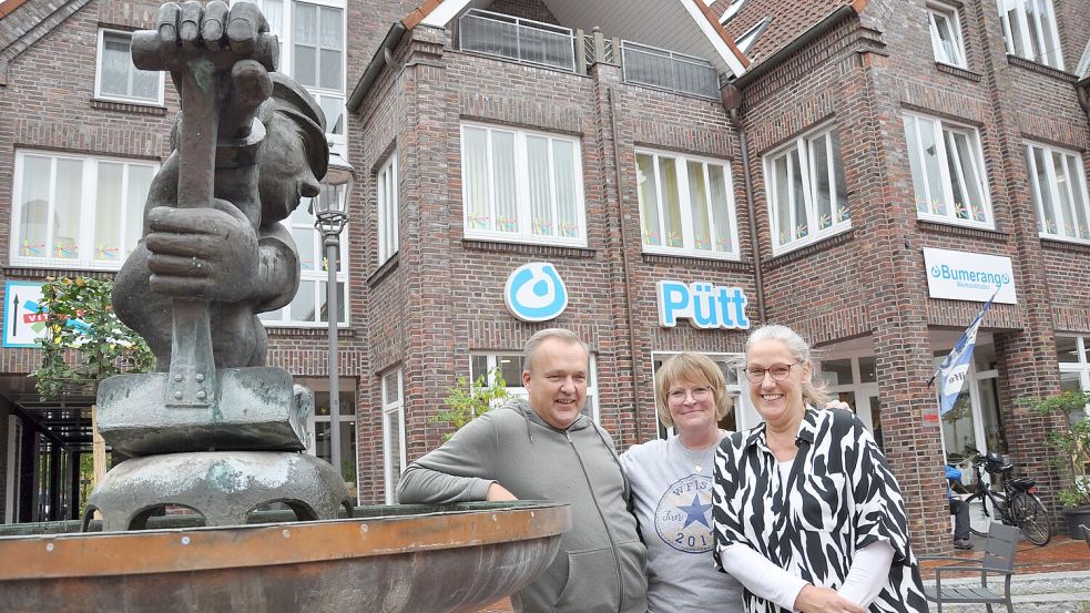 Birgit Hardtke (von rechts), Birgit Hullena und Stefan Bollmann vor der Freizeitstätte „Huus bi d′ Pütt“ an der Wittmunder Brückstraße. Der ortsbildprägende Jan-Schüpp-Brunnen fungiert als Namensgeber. Foto: Ullrich