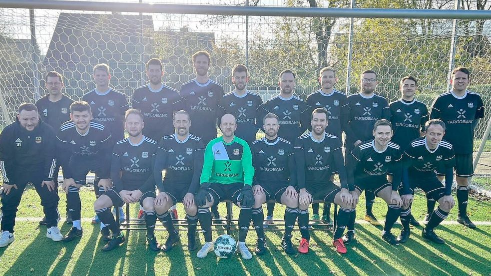 Die SuS-Mannschaft mit Familiensinn stellte sich vor der denkwürdigen Partie gegen Upleward für ein Foto ins Fußballtor. Auch Teamchef Andreas Ammersken (hinten, Fünfter von links) war nach langer Pause wieder dabei. Foto: Privat