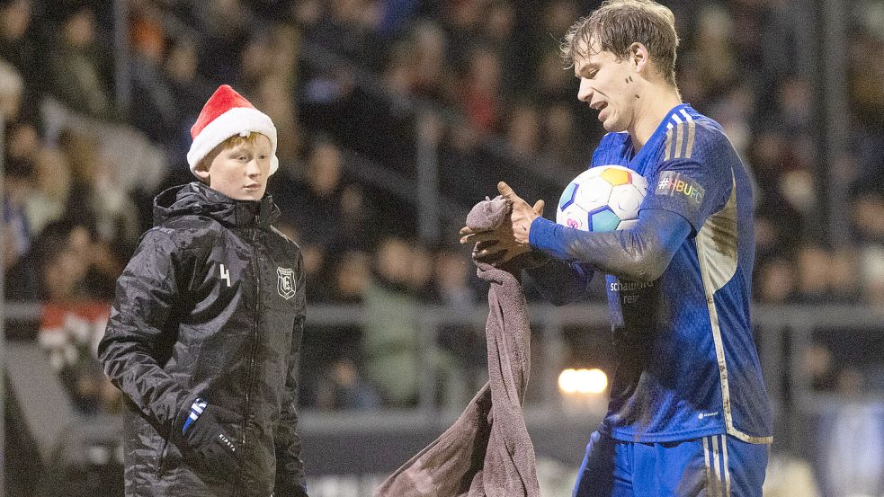 Die Balljungen von der D1 von Rot-Weiß/Kickers Emden trugen sogar Nikolausmützen. Matthias Buffen beobachtet David Schiller, wie er den Ball vorm Einwurf säubert.