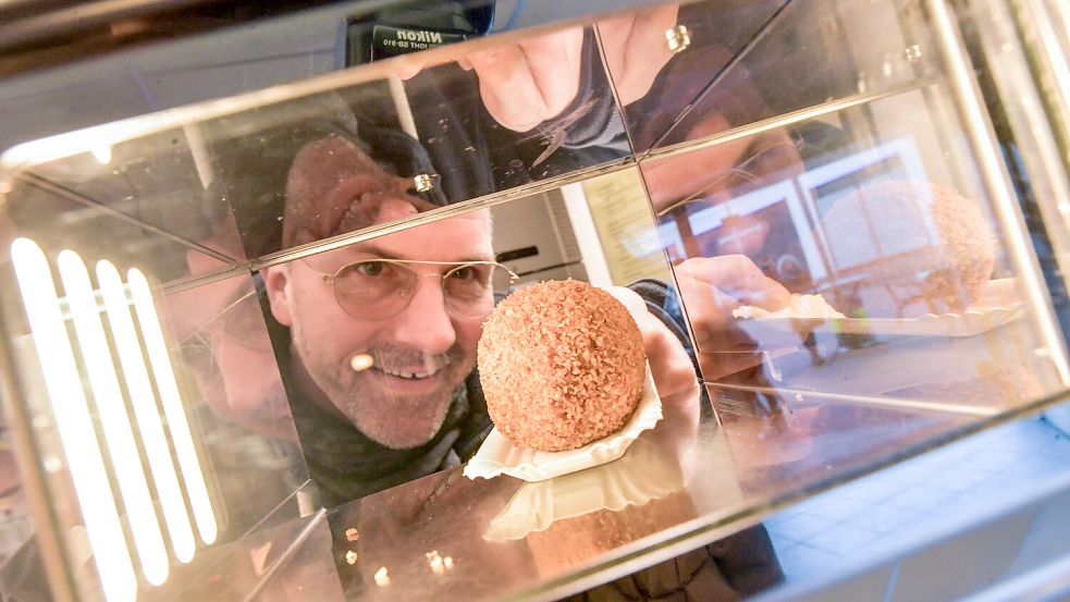 Hinter den Automatenfenstern verbirgt sich die Imbiss-Küche. Arjan Kenter sorgt gerade mit einem Eierbal für Nachschub und füllt das leere Fach. Foto: Ortgies