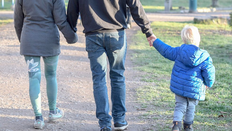 Familienausflug- Eltern mit Kind gehen in einem Tiergehege spazieren. *** Family outing parents with child walk in an an Foto: IMAGO/Winfried Rothermel