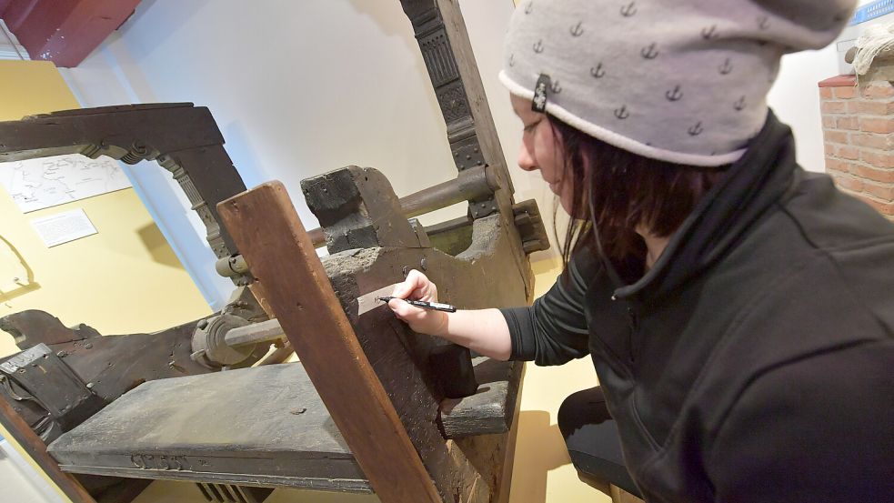 Möbelrestauratorin Mirja Harms beschriftet ein Element des Webstuhls. Foto: Ortgies