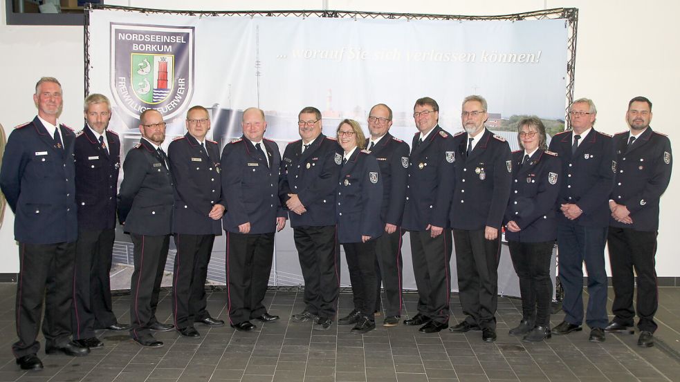 Gruppenbild mit Geehrten, eingerahmt vom stellvertretenden Stadtbrandmeister Andreas Harms (links) und Stadtbrandmeister Aike Brinkmann (rechts). Foto: Ferber