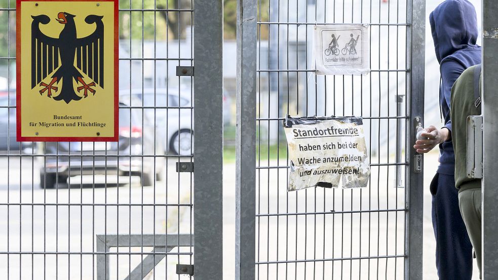 Ein Mann betritt neben einem Schild vom Bundesamt für Migration und Flüchtlinge die Landesaufnahmebehörde Niedersachsen am Standort Braunschweig. Foto: Stratenschulte/DPA/Archiv