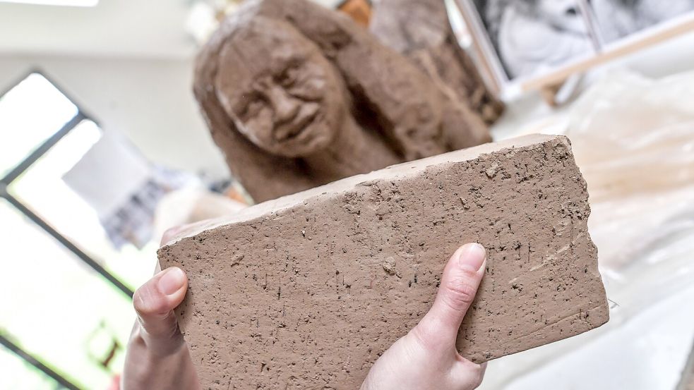Nach einer Weile in den Händen von Nic Schaatsbergen ist der Lehmrohling (im Vordergrund) nicht mehr als solcher erkennbar. Erst in der fertigen Skulptur wird die Steinstruktur wieder deutlich. Foto: Ortgies
