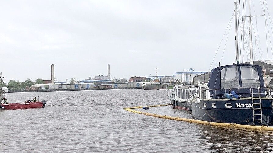 Links neben den beiden Booten, wo die Ölsperre-Vorrichtung zu sehen ist, ist ein etwa zehn Meter langes Motorboot am Freitag gesunken. Es wurde am Samstag geborgen. Foto: Hanssen