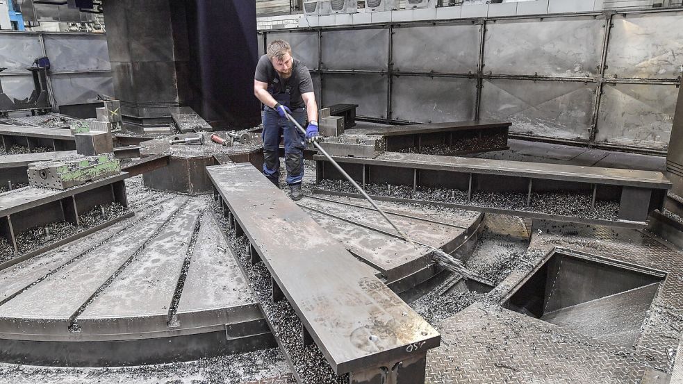 Hendrik Meyer schiebt an einer Karusselldrehmaschine die großen Eisenspäne zur Seite. Foto: Ortgies