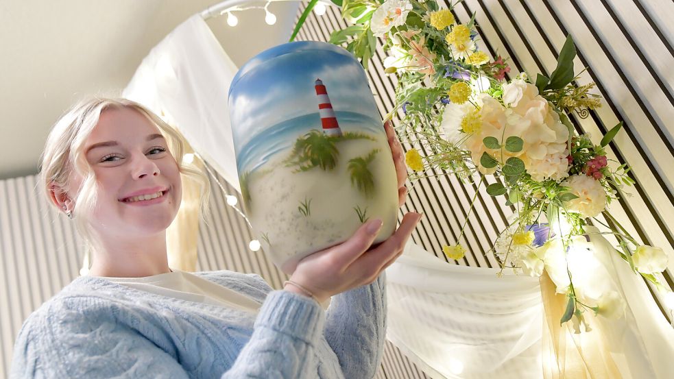 Marie Janssen zeigt ein Urnenmodell, das sich viele Menschen, die Ostfriesland und die Küste mögen, noch zu ihren Lebzeiten selbst aussuchen. Foto: Ortgies