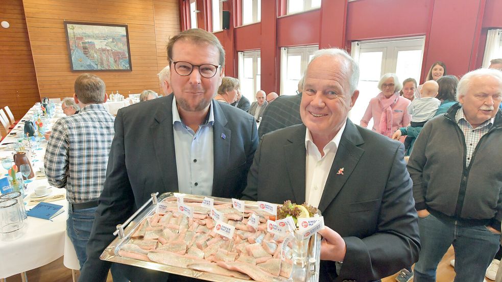 Oberbürgermeister Tim Kruithoff (links) und Frank Nowak vom Arbeitskreis Matjestage mit einem Tablett voll Matjes.