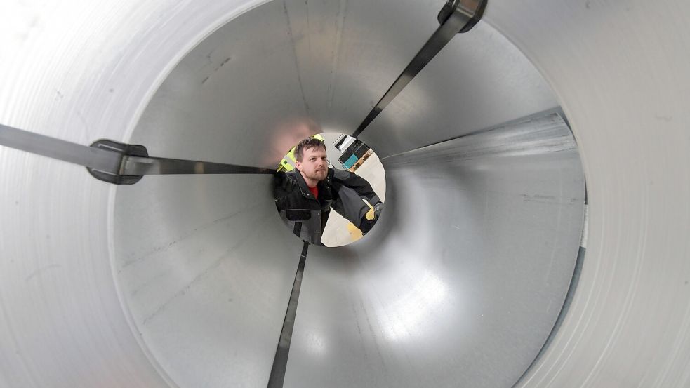 Mitarbeiter Hauke Jan Heyen blickt durch eine Rolle Blech. Foto: Ortgies