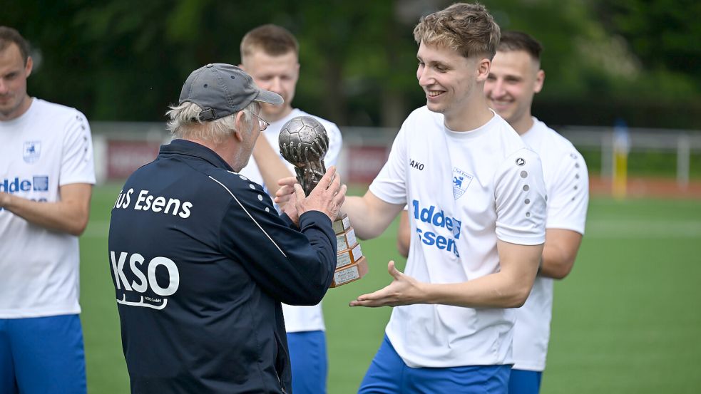 Finn Rosenboom wurde von den TuS-Fans zum „Spieler der Saison“ gewählt. Den Wanderpokal erhielt er von TuS-Betreuer Heiko Feddermann. Fotos: Doden/Blomberg