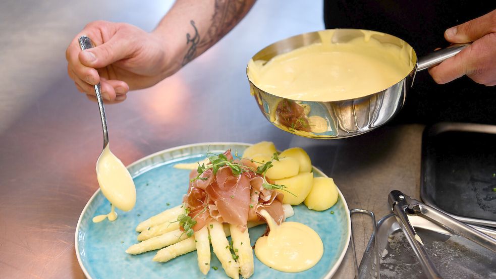 So mögen viele Spargelfans das Stangengemüse am liebsten: klassisch mit Kartoffeln, Schinken und Sauce Hollandaise. Foto: Ortgies/Archiv