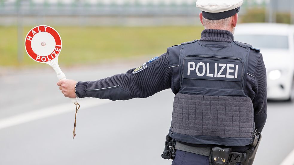 Ein Beamter der Bundespolizei stoppt bei der Kontrolle des Einreiseverkehrs am deutsch-tschechischen Grenzübergang den Fahrer eines Autos bei der Einreise. Foto: Daniel Karmann/dpa