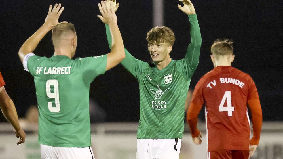Marten Hoffmann (Mitte) brachte Larrelt gegen Vizemeister Bunde in Führung. Kapitän Torsten Mammen war einer der ersten Gratulanten. Foto: Doden, Emden