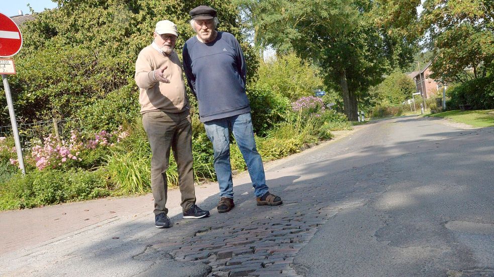 Die Löcher in der Kampstraße klaffen dort schon einige Zeit. Für Rolf Westernhagen und Theo Klasen ist das ein unhaltbarer Zustand. Foto: Lüppen