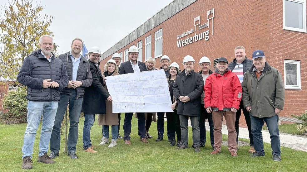 Bauhelme und der Bauplan dürfen schon mal mit aufs Bild, denn noch Ende des Jahres sollen die ersten Arbeiten an der Westerburgschule beginnen. Zu sehen sind hier (von links) Gerold Verlee (CDU), Matthias Arends (SPD), Architekt Marten Ulpts, Doris Kruse (SPD), Projektleiter Thomas Kuske, Oberbürgermeister Tim Kruithoff, GME-Leiterin Freia Visser, Schulhausmeister Heinz Penning, Schulleiterin Silvana Jung, Alexander von Gliszczynski (FDP), Detlef Kruse (SPD), Horst Müller (GfE), Fachdienstleiter Michael Groeneveld und Erich Bolinius (FDP).
