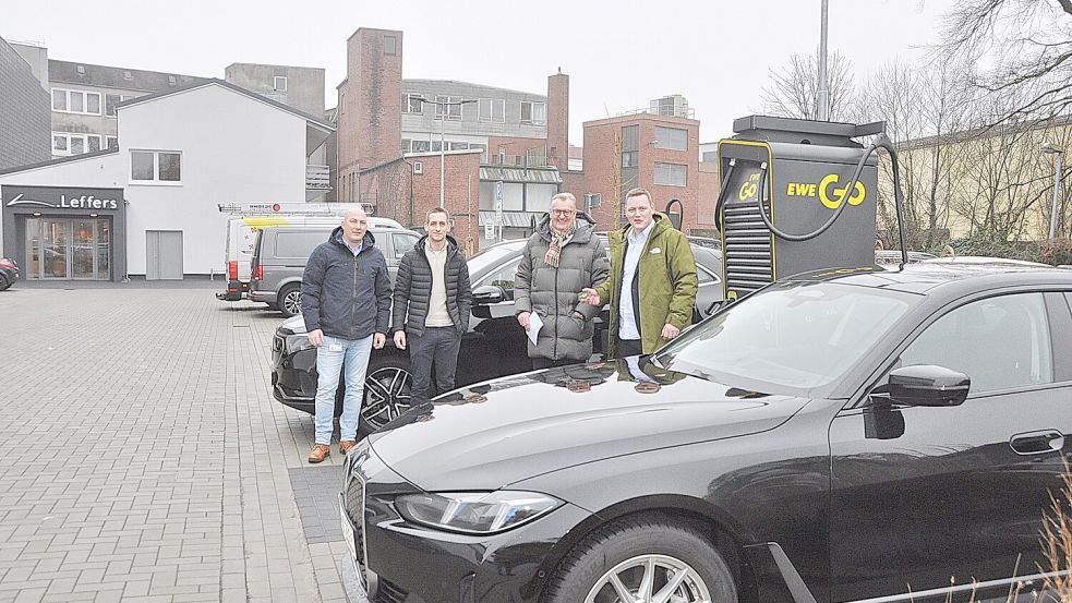 Stefan Becker (links) und Matthis Berg (rechts) von EWE Go stellten gemeinsam mit Leffers-Geschäftsführer Johannes Poppen (Zweiter von rechts) und Leffers-Hausverwalter Dennis Reck die neuen Ladesäulen auf dem Parkplatz des Modehauses vor. Foto: Wolters