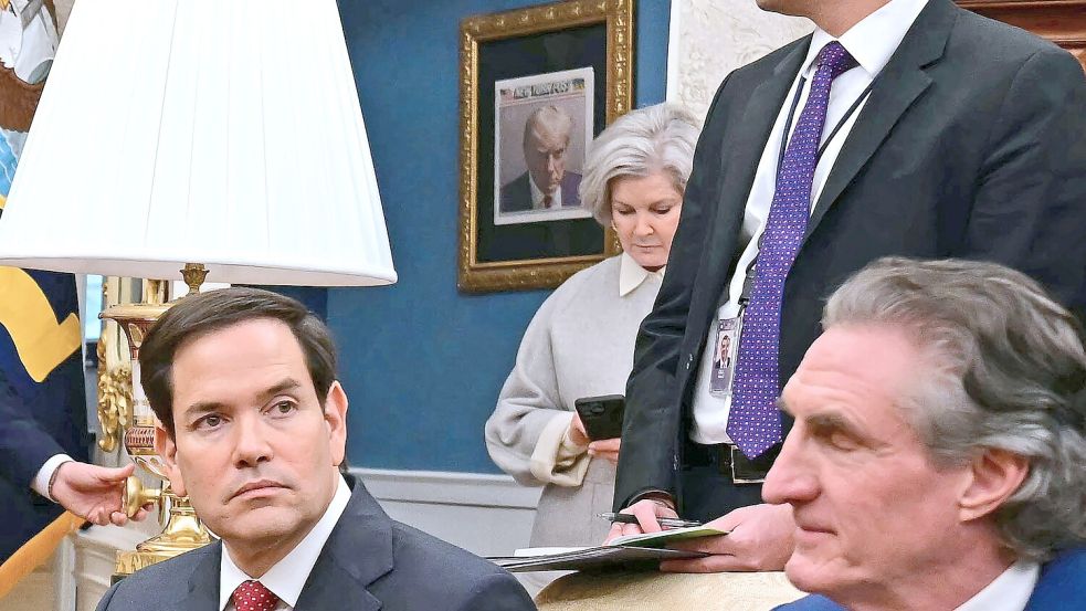 Mitarbeiter und internationale Gäste gehen nun an Trumps Polizeifoto vorbei in sein Amtszimmer. Foto: AFP/JIM WATSON
