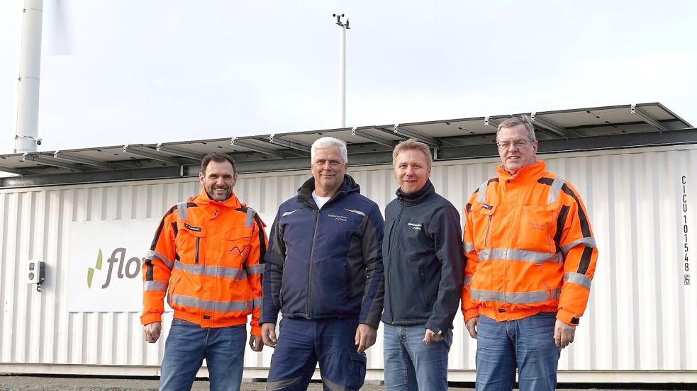 Vier Männer, ein Projekt (von links): Matthäus Wuczkowski (Abteilungsleiter Nachhaltigkeit und Innovation bei NPorts), Jens Kampen (Elektrotechnik bei NPorts in Emden), Aiko Hollander (Leiter NPorts-Niederlassung in Emden) und Thomas Tröster (Teamleiter Elektrotechnik bei NPorts in Emden) or der Container-Windkraftanlage. Foto: Mädler/NPorts