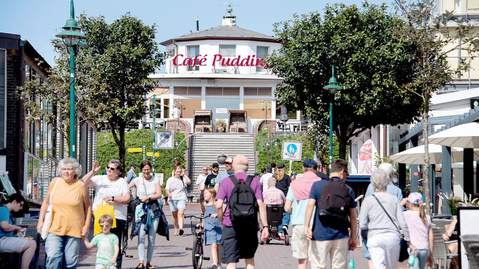 Touristen gehen bei sonnigem Wetter durch den Ortskern der Insel Wangerooge. Foto: Dittrich/dpa