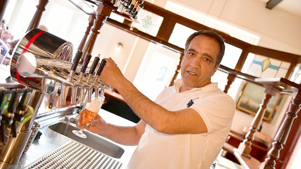 Necmettin Tan, einer der neuen Betreiber der Greetsieler Börse, zapft schon mal ein Bier für die ersten Gäste.