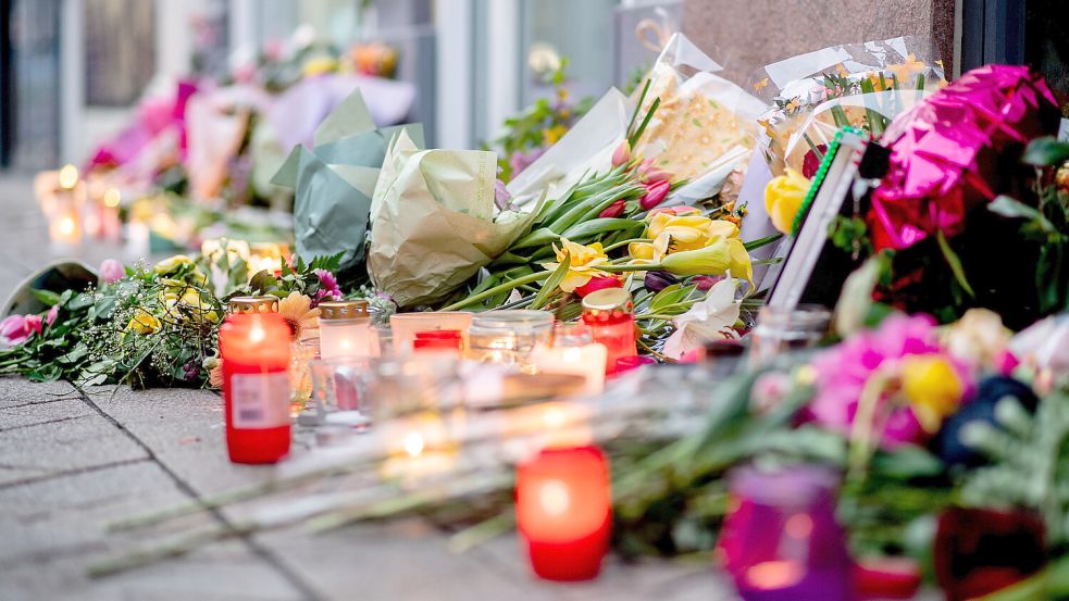 Zahlreiche Blumen und Kerzen stehen in der Oldenburger Innenstadt an einer Hauswand in der Achternstraße, in der am frühen Ostersonntagmorgen ein Mensch von Schüssen aus einer Polizeiwaffe tödlich verletzt wurde. DPA-Foto: Dittrich