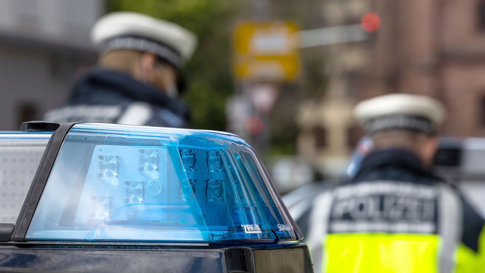 Zwei Polizeibeamte stehen zwischen zwei Einsatzfahrzeugen der Polizei. Foto: dpa/Philipp von Ditfurth